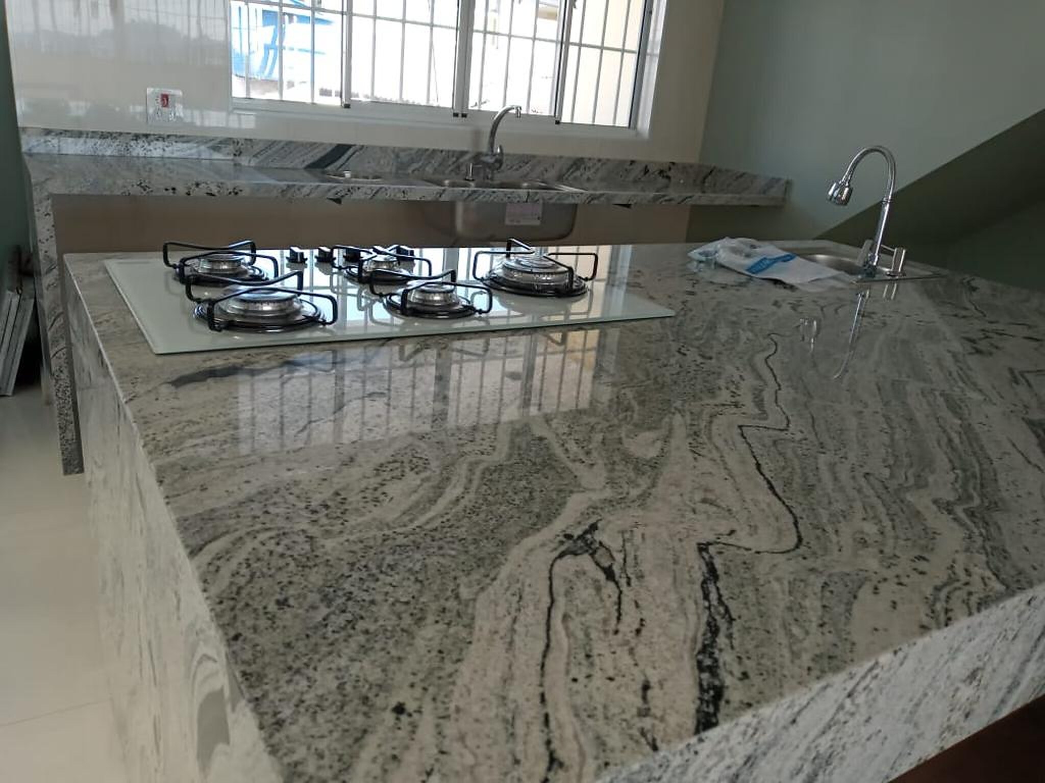 bancada de cozinha em pedra clara com recortes e uso real